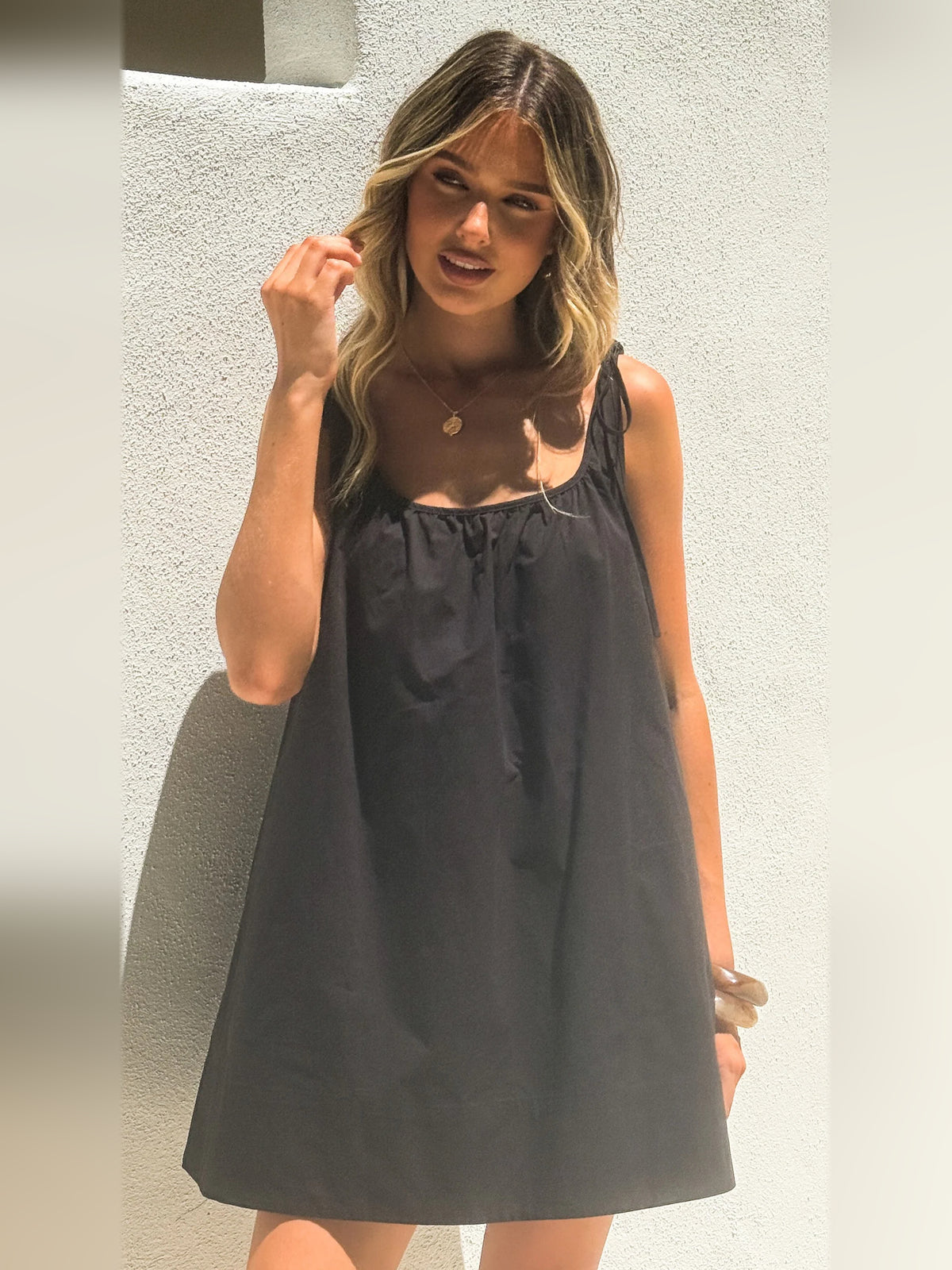 Black mini homecoming dress, alternate view showing the dress shape and hem
