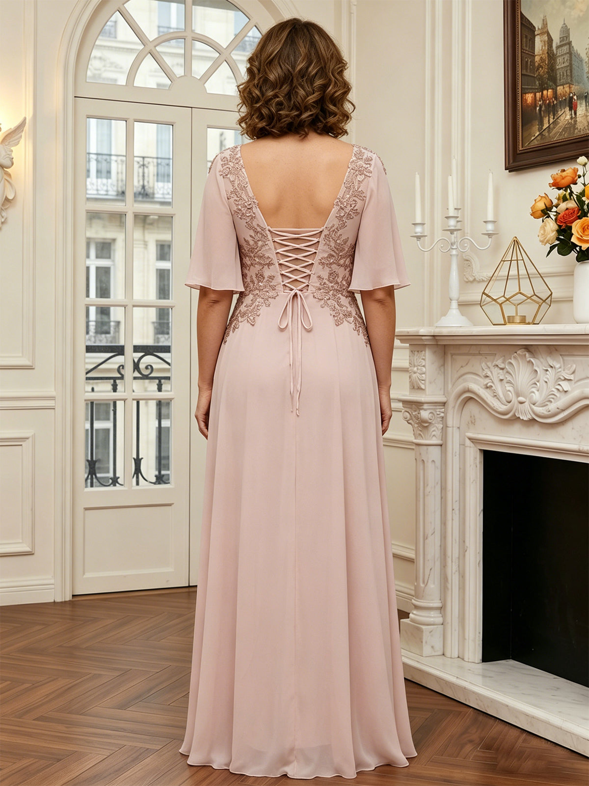 floor length chiffon mother of the bride A-line gown with flutter sleeves and beaded lace applique shown on model in a formal wedding guest styling