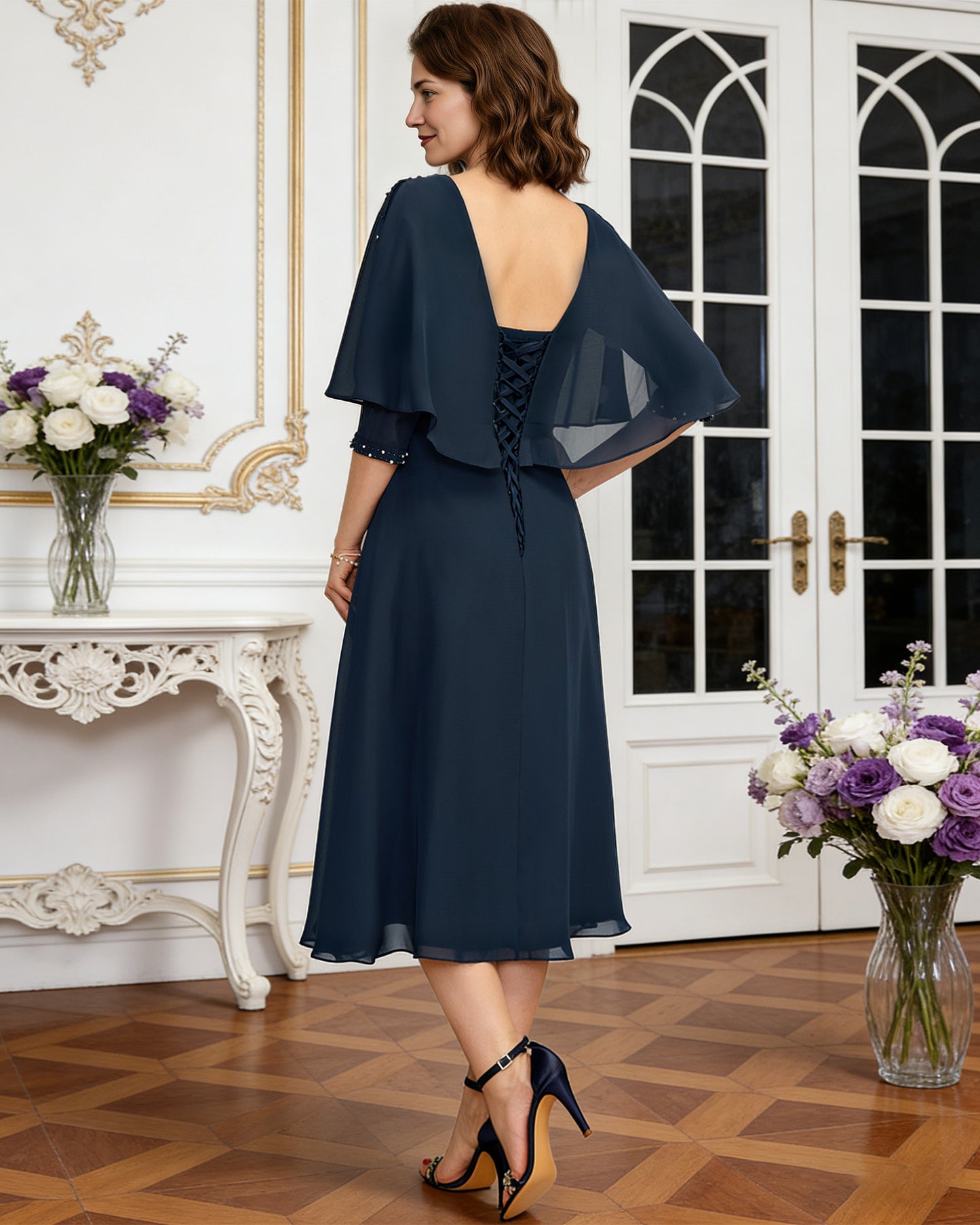 tea length chiffon mother of the bride dress with beaded cape overlay and A-line skirt alternate angle showing the formal dress silhouette and drape