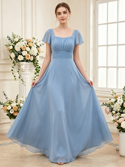 blue A-line bridesmaid dress styled in a bright bridal suite with soft chiffon skirt and flutter sleeves